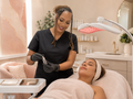 Tima preparing an advanced facial treatment with professional LED equipment at Boujie and Bare Esthetics